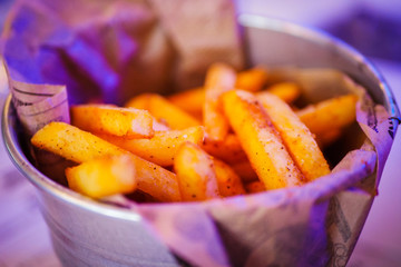 Hot and crispy golden french fries in a small metal bucket