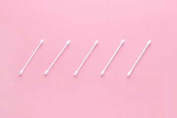 white cotton swabs on pink background, flatlay