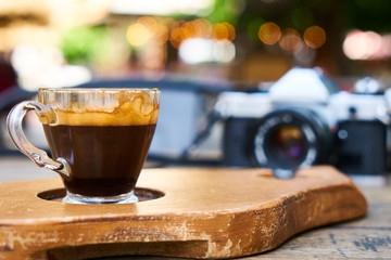 Dark espresso coffee and retro film camera