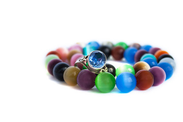 Cat's eye quartz necklace and bracelet, selective focus on white background isolated. Colourful precious stones.