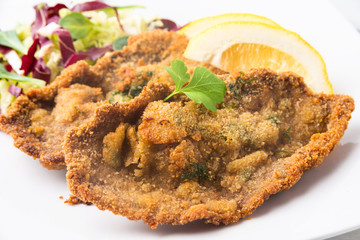 Cotoletta alla milanese con contorno di verdura fresca, cibo italiano