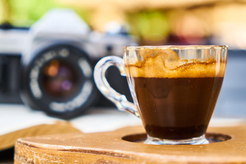 Dark espresso coffee and retro film camera