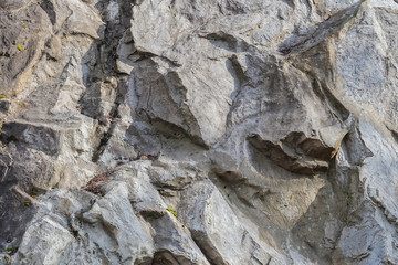 Closeup surface natural stone wall at the park textured background with sunlight