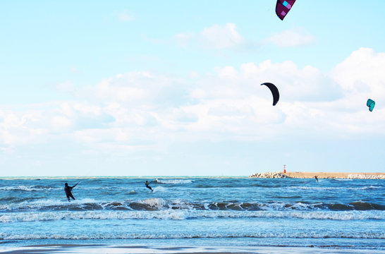 two men are kitesurfing in a stormy sea