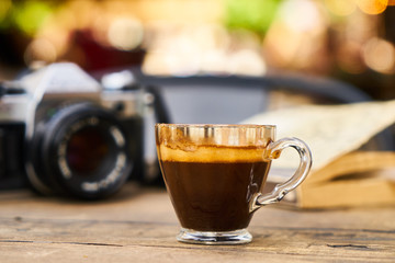 Dark espresso coffee and retro film camera