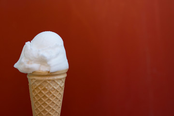 white ice cream in cone, against red background. space for text