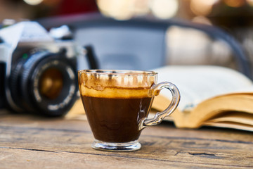 Dark espresso coffee and retro film camera