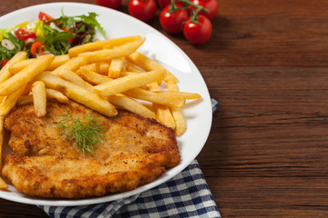 Chicken schnitzel, served with fries and salad.