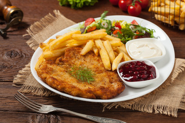 Chicken schnitzel, served with fries and salad.