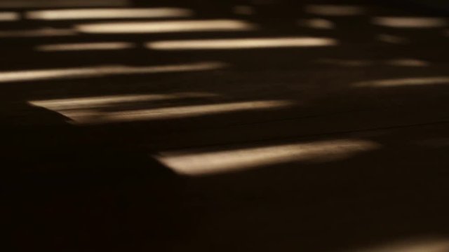 Shadows of electric window shutters being opened - showing on parquet floor