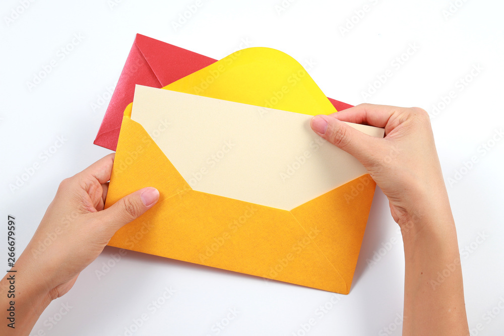 Wall mural Top view female hands holding a blank card with colorful envelopes on the table, isolated on white background