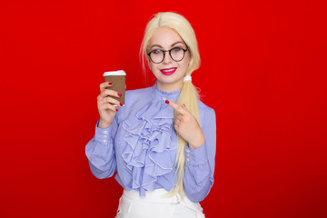 Blond business woman holding paper cup with coffee