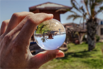 Rescue beach hut for doctors and nurses in Polis, Cyprus. All of it, it is in lens ball. Man is holding glass ball and in is wooden cabin for beach doctors