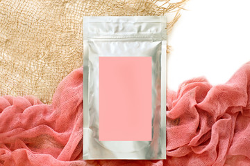 Foil packaging for loose cosmetic products, with a pink sticker, cloth and dried flowers, natural...