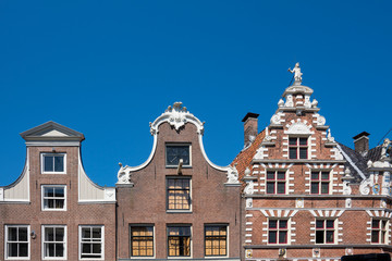 Fototapeta na wymiar stepped gable of typical dutch houses Hoorn, The Netherlands, against blue sky