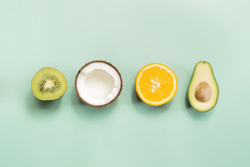 Kiwi fruit, coconut, orange and avocado on green background. Concept of fruitarianism, vegetarianism, veganism, natural vitamins and health. © Photoboyko