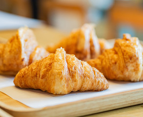 Croissant close up on wooden plate