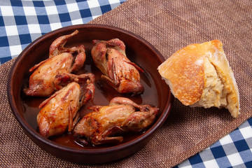 Roasted quail and Chunk of white bread. Rustic style.