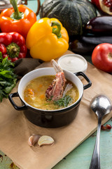 Shurpa soup with lamb in pot on blue wooden table