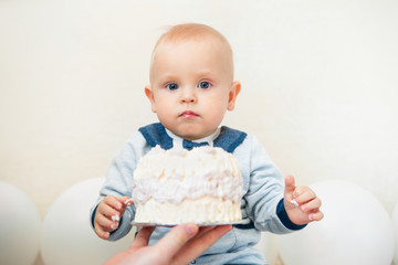 One year baby birthday party. Baby eating birthday cake. Boy portrait