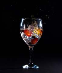 Glass with ice, fruit and drops of splash