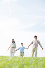 草原で手をつなぐ家族