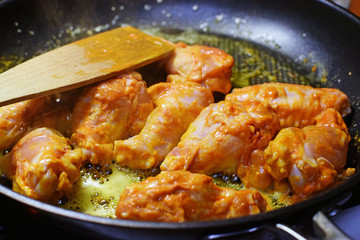 Hot chicken wings on frying pan