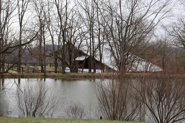 The reflecting pond water with the old wood barn.