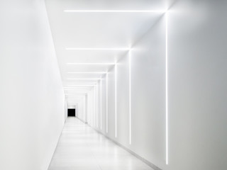 Empty white tunnel with a dark exit at the end.
