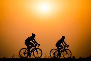 Silhouette man cycling on sunset background