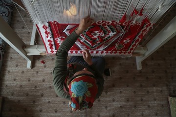 Obraz premium Woman hands weaving a handmade carpet .Kayseri/Turkey