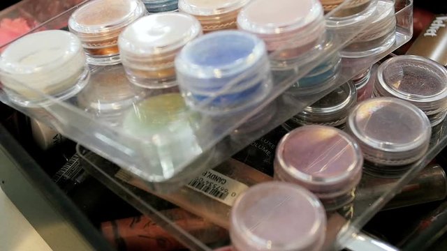 Closeup slow motion video of assortment of cosmetics, shades, paints and cremes in professional makeup artist studio