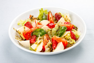 Caprese salad with strawberries. Salad with mozzarella, tomatoes, Basil and strawberries. On white background