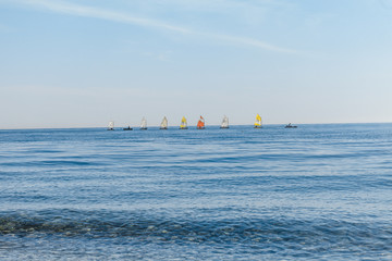 sailboats on the horizon are sailing on the blue sea