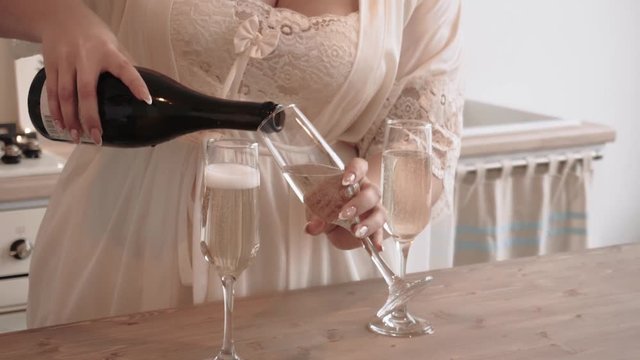 girl pours champagne in a glass