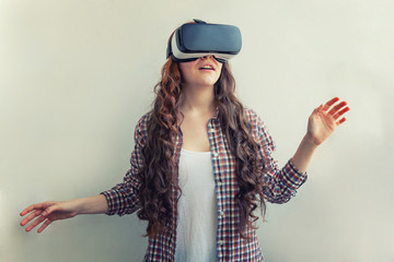 Smile young woman wearing using virtual reality VR glasses helmet headset on white background. Smartphone using with virtual reality goggles. Technology, simulation, hi-tech, videogame concept