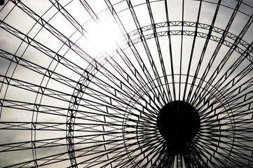 The sun shining behind a fairground attraction