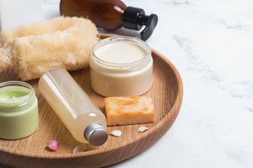 Natural cosmetics in small bottles on the white marble table