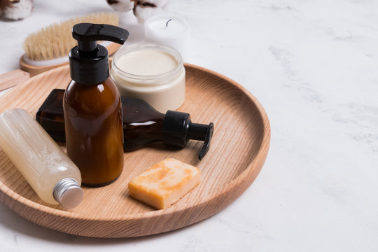 Natural cosmetics in small bottles on the white marble table