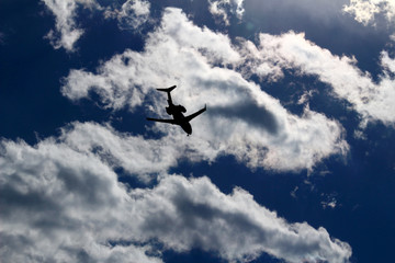 Fototapeta na wymiar A jet airliner flying under the sun shining in the sky