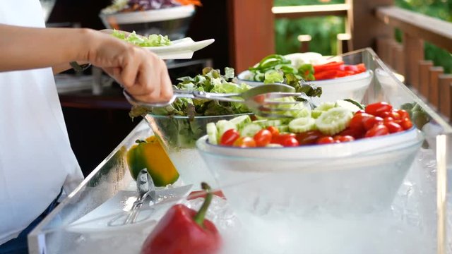 4K. woman select different organic vegetable on catering buffet food in hotel restaurant with colorful fruits and vegetables for salad food ,vegetarian. food fitness diet healthy lifestyle