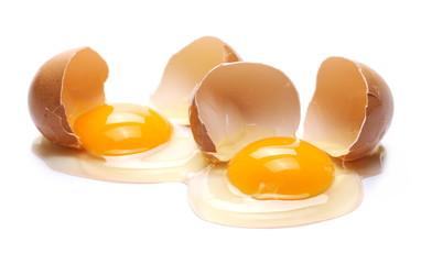 Cracked eggs, eggshells with yolk isolated on white background