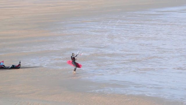 Kitesurfer Running on Coastal Sands