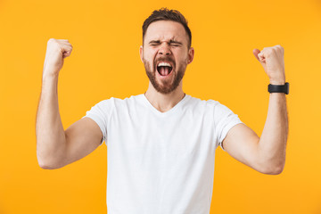 Fototapeta premium Man posing isolated over yellow wall background make winner gesture.