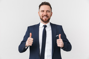 Young businessman posing isolated over white wall background showing thumbs up.