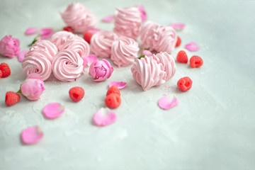 Homemade marshmallow with powdered sugar raspberries roses on gray concrete background