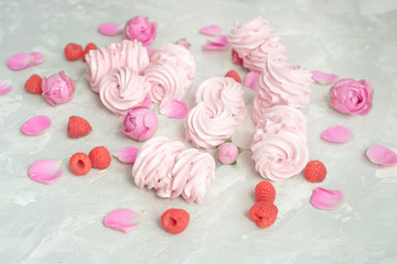 Fototapeta na wymiar Homemade marshmallow with powdered sugar raspberries roses on gray concrete background