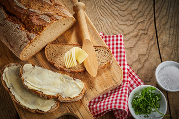 Buttered slices of rye bread with bowls of parsley