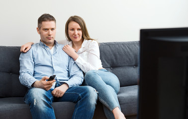 Man and woman watching TV at home.