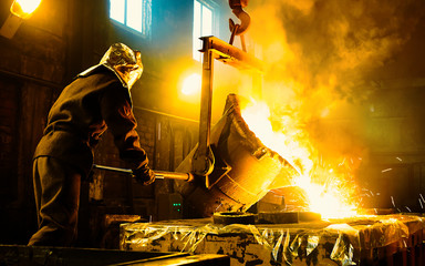 Worker controlling metal melting in furnaces. Workers operates at the metallurgical plant. The...